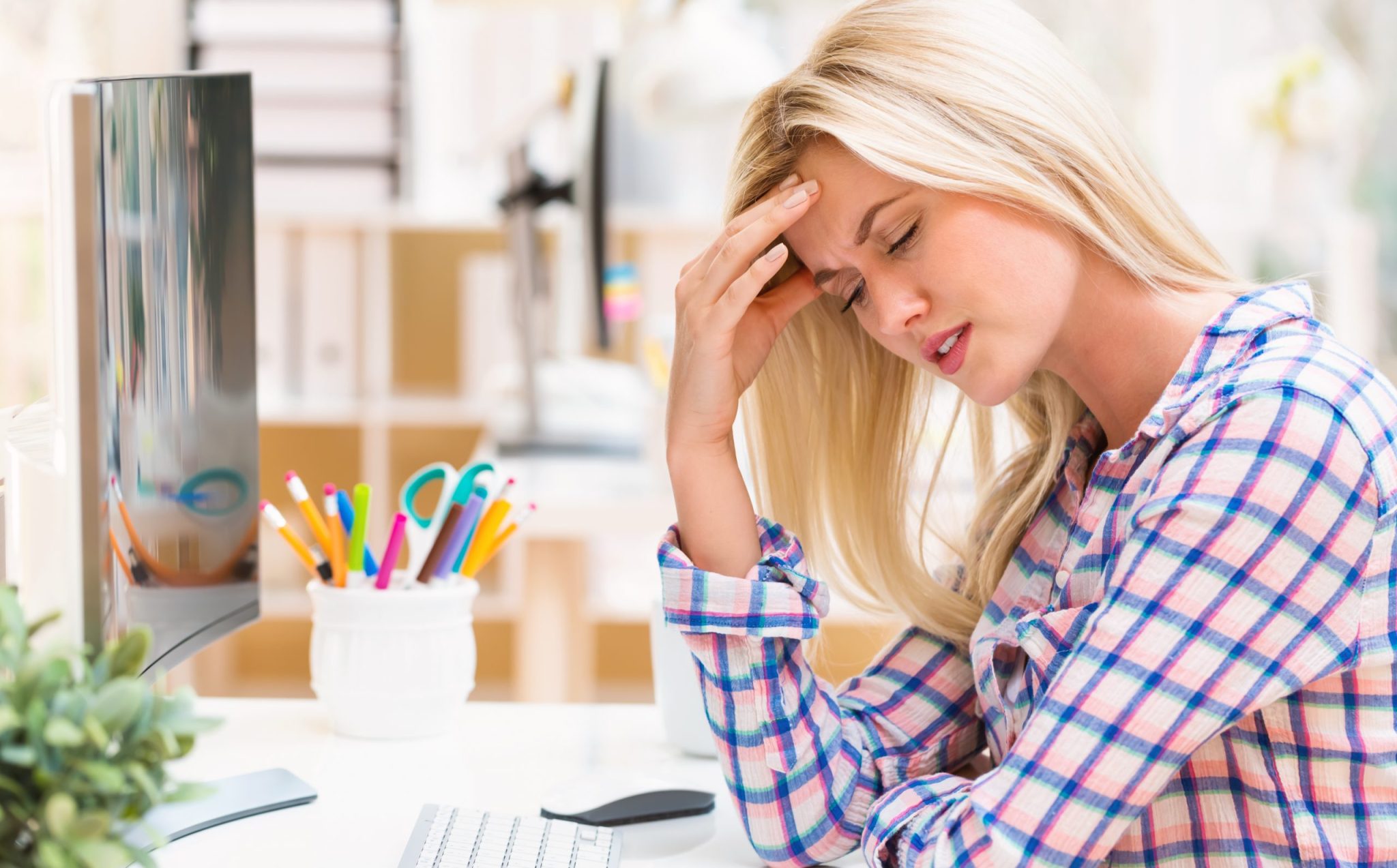 Young woman feeling stressed at her desk